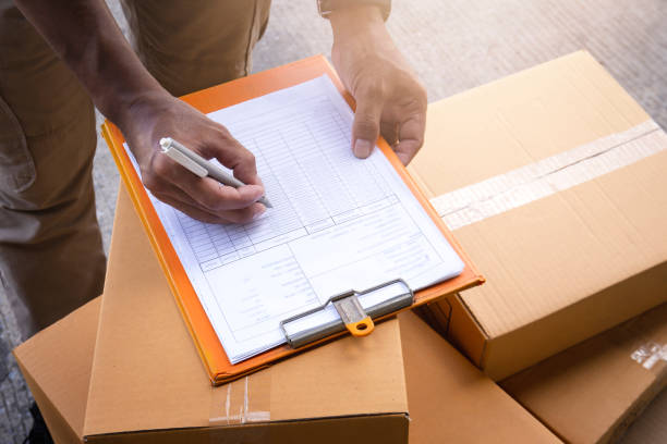 Nhân viên logistics đang ghi thông tin lên bảng kê chứng từ xuất nhập khẩu, đặt trên thùng hàng – minh họa cho thủ tục xuất nhập khẩu khi gửi hàng đi Đức.