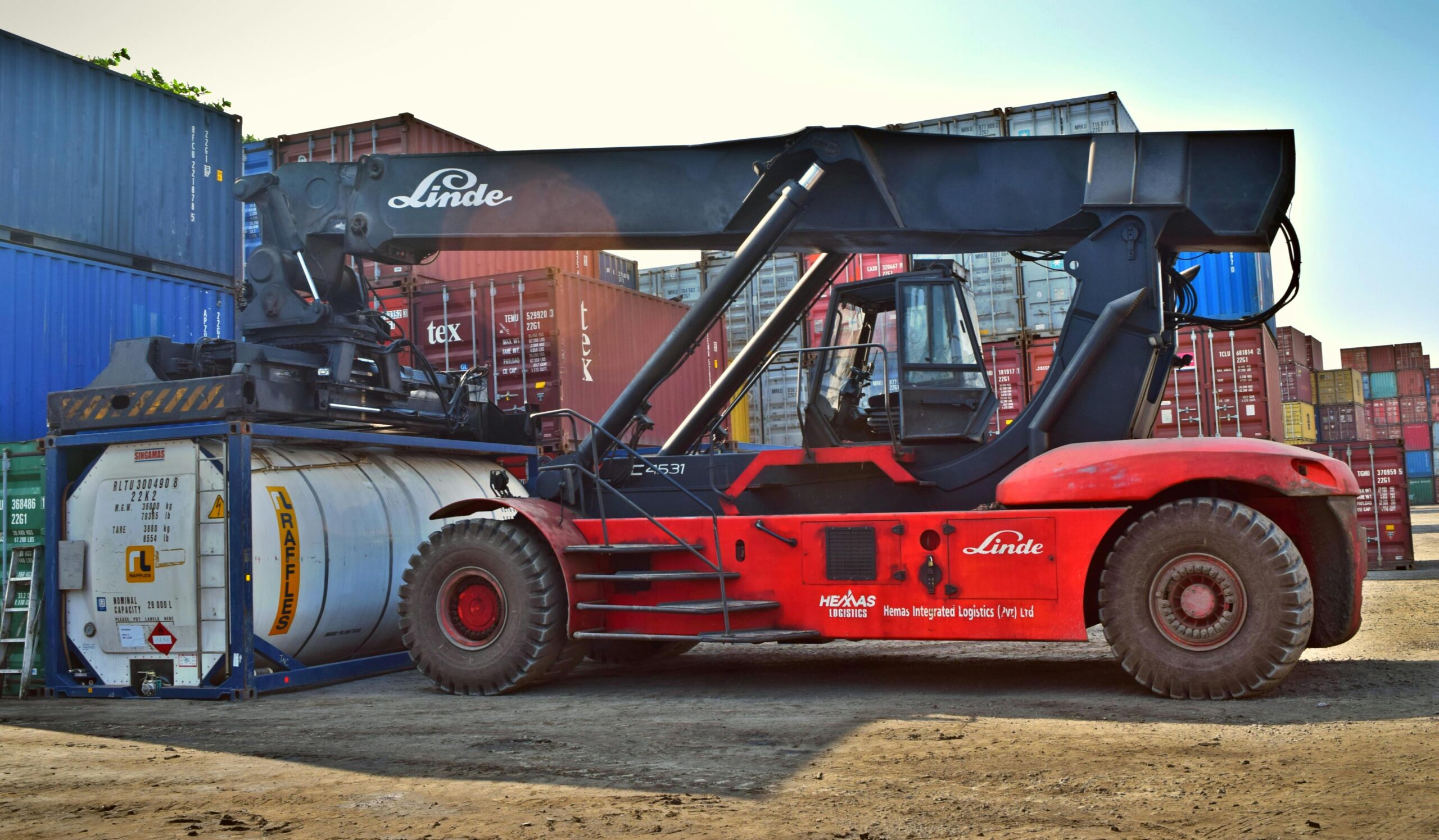 Xe nâng container bốc xếp hàng công nghiệp trong khu vực cảng, minh họa quy trình chuyên nghiệp khi gửi máy móc và linh kiện sang Đức bằng đường biển và hàng không.