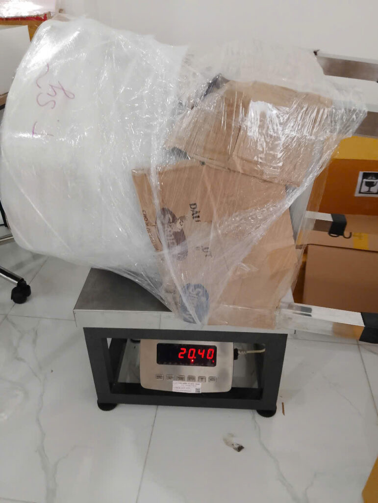 Kiện hàng nồi inox và vật liệu đóng gói được cân đo trước khi gửi đi Đức, minh họa kinh nghiệm gửi hàng đi Đức cho hàng cồng kềnh và dễ móp méo.